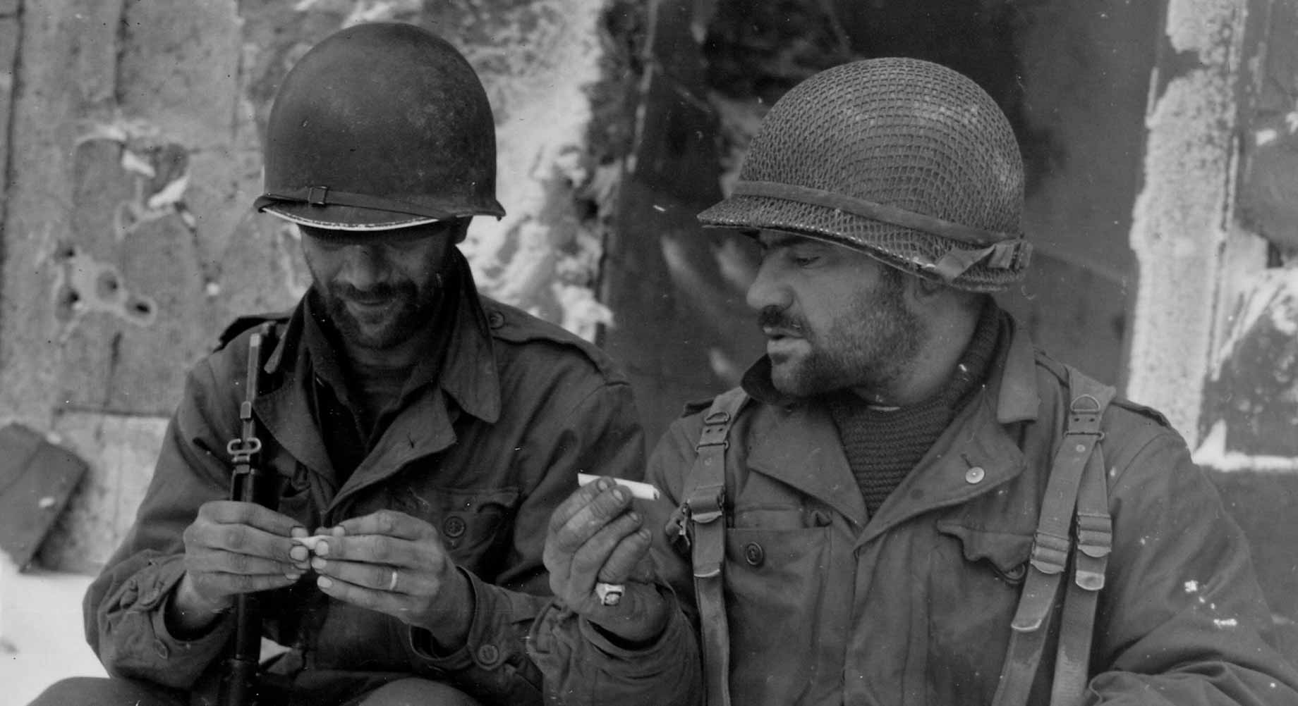 Deux soldats du 317e régiment d'infantrie se roulent une cagarette, 10 janvier 1945, Luxembourg